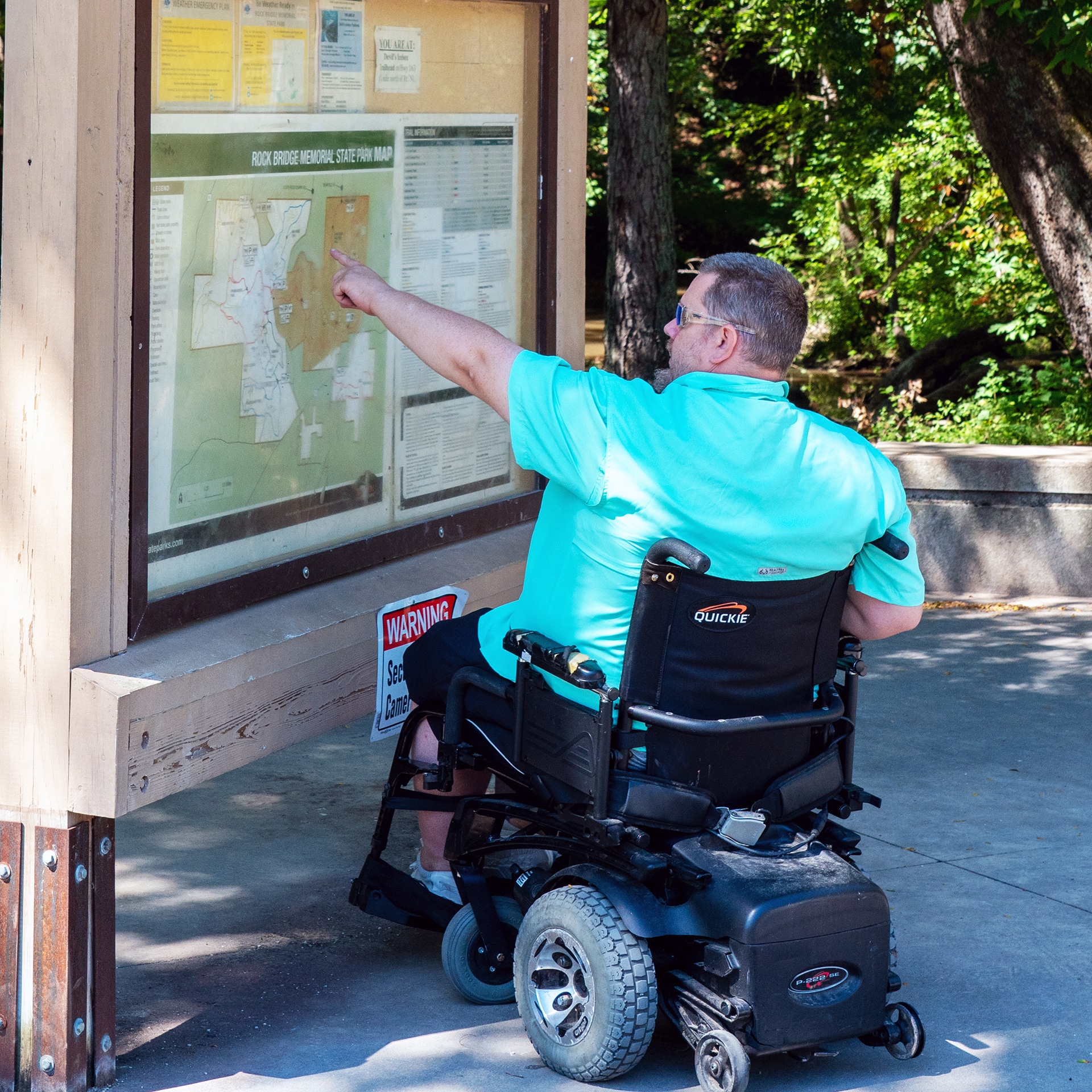 A visitor uses the map on display at Rock Bridge Memorial State Park to navigate the accessible paths